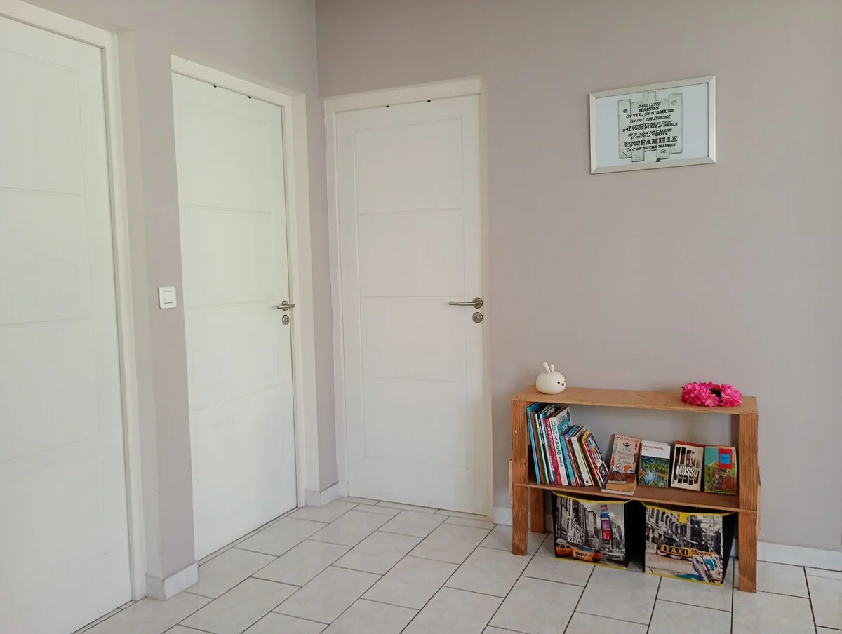 Hallway leading to the bedrooms, with a small shelf of books and magazines