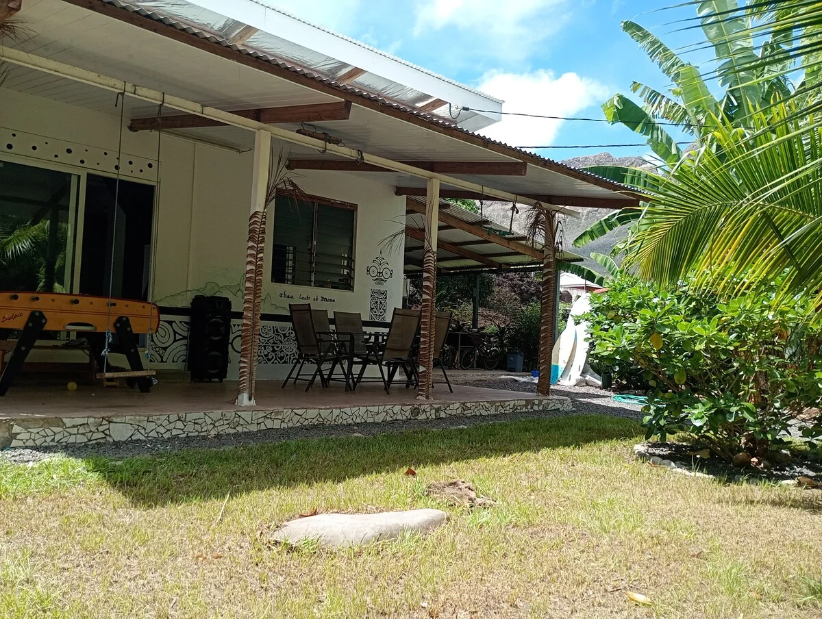 The covered terrace with table and chairs, a table football and a garden of banana trees