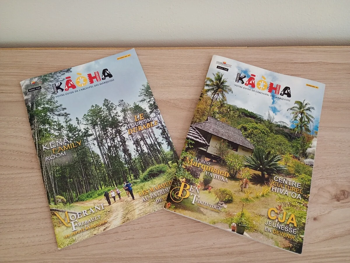 Two issues of Kaoha, the Marquesas Islands magazine, on a wooden table